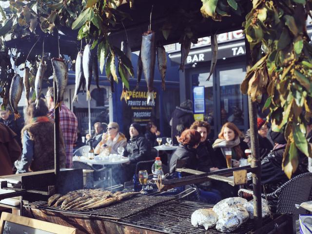 Des visiteurs attablés en terrasse d'une restaurant du quai Henri 4 pendant la foire aux harengs