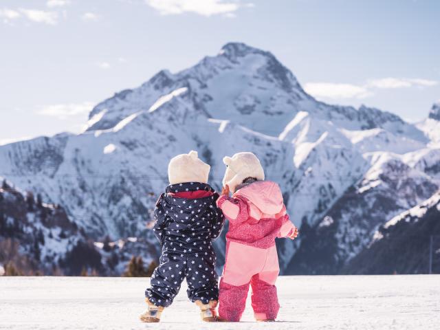 De jeunes enfants en promenade face à la Muselle sur le front de neige de la station des 2 Alpes