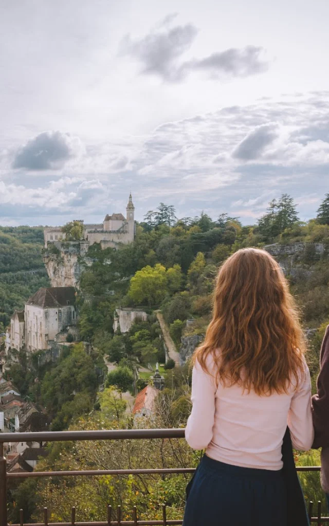 Une mère et sa fille se tiennent sur le belvédère du photographe de Rocamadour et observent la cité médiévale accrochée à la falaise.